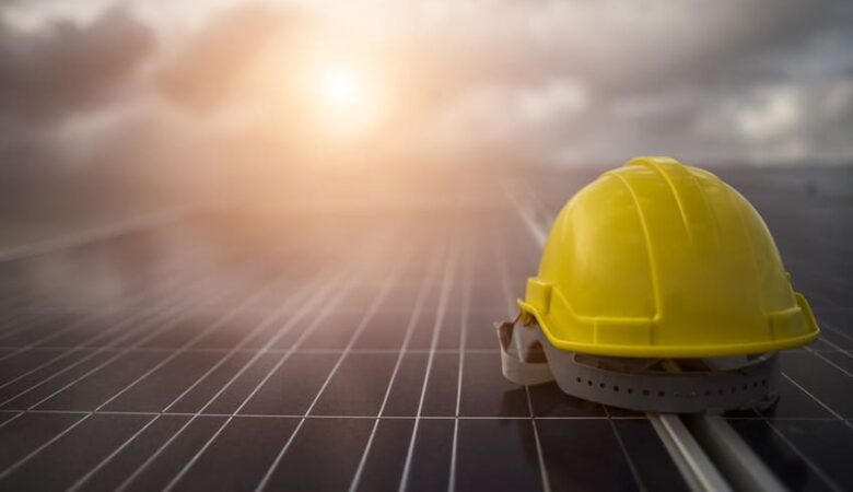 capacete em cima da placa de energia solar
